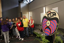 Iris Frank (centre), Tla-o-qui-aht's education manager, looks proudly at a design that was unveiled at the gathering, composed of paper feathers on which participants wrote the names of people, past and present, who took up the cause of language revitalization.  