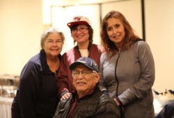 Former Huu-ay-aht chief councillor Robert Dennis sits with wife Sarah Dennis (left), granddaughter Dani and daughter Jacquie at the AGM. (Eric Plummer photo)