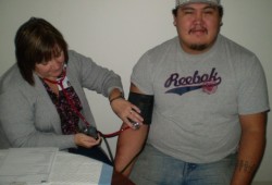 NTC nurse Deb Melvin takes a client’s blood pressure at a health fair in November 2011.