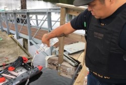 Wally Thomas, Chief Hohomiius, an Ahousaht Tribal Police officer, dumps out a confiscated bottle of vodka at the main dock in Ahousaht in 2020. In a measure to discourage gatherings and prevent the spread of COVID-19, Ahousaht blocked the arrival of booze during the coronavirus lockdown. (Submitted photo)