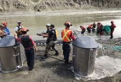 Beach seining teams transfer salmon into containers for helicopter airlift over the Big Bar landslide near Lillooet. 