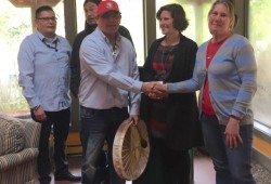 Dwayne Martin of Kliith Pi-taap Taaq Men's Group and Margaret Morrison of the West Coast Resources Society shake hands on partnerships with Rebecca Hurwitz, CBT Executive Director, looking on. 