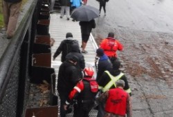 DFO officers and Mowachaht/Muchalaht members carry the orca up the Gold River boat ramp.