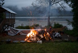 Carl Martin prepares a fire in the early morning, heating rocks for canoe steaming. (Christine Germano photo)