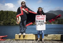Cameron Graham (left) and Alexis Williams stand on the edge of the main street dock in Ucluelet, peacefully protesting the deaths of Chantel Moore and George Floyd, on Sunday, June 6.