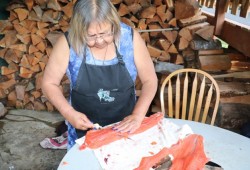 Tseshaht elder Linda Thomas demonstrates how to fillet salmon.