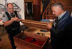 Cst. Pete Batt and Cpl. Jay Donahue of the First Nations Community Policing Unit receive a box full of eagle feathers from School District 70.