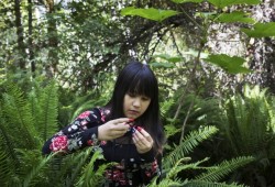 Alexyss Howard, 14, eats fresh salmonberries in the forest just outside of Port Alberni.
