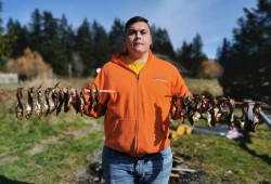 Hesquiaht member Joshua Charleson holds herring he smoked with his wife, Letitia, outside their home in Port Alberni. (Letitia Charleson photo)
