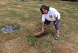 Agnes Jack lifts up sod where her daughter’s gravestone had been incorrectly placed. The cemetery has vowed to ensure Melissa Jack’s grave is in the right spot.