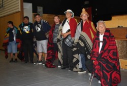 Ahousaht Ha’wilth Ron George stands with others who were blanketed at Hahahinuu Ahousaht Gathering.