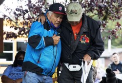 Tom Curley is comforted by Larry Baird after speaking to a crowd of people gathered in Tofino's Village Green to honour the survivors and victims of the residential school system on the first National Day for Truth and Reconciliation, on September 30, 2021.