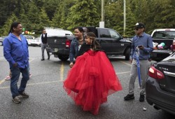 Anna Patrick lifts her gown as she walks towards the lighthouse in Ucluelet for graduation photos.