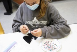 Payton Black, 10, sews sequins into a felt Christmas tree decoration at the Wickaninnish Community School, in Tofino, on November 22, 2021.