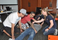 From left to right, trainees Hank Gus and Aaron Watts secure "victim" Dean Charles, aided by instructors Justin Beaumont and Candace Winter.