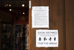 Social distancing signs are taped up at the entry of the House of Himwitsa Native Art Gallery, in Tofino.