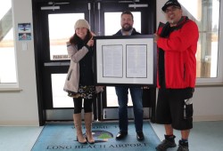 Jenny Brunn, ACRD general manager of community services, ACRD CAO Daniel Sailland and TFN lands and resources manager Saya Masso hold a framed copy of the Meares Island Declaration for the airport terminal.