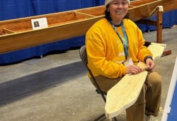 Lydia Brown, who is of Snuneymuxw (Nanaimo) and T’Souke (Sooke) First Nation descent, works on a traditional paddle. (Canoe Carving Society photo)