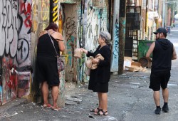 Squamish Nation Elder Florence Williams offers a young woman on the Downtown Eastside a sandwich during the All Nations Outreach Society during lunch distribution on Aug. 27, 2025. (Nora O’Malley photo)
