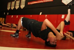 Wrestlers perform exercises at the beginning of a practice at ADSS.