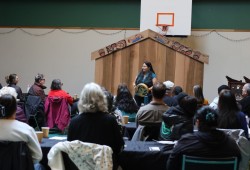 Language warrior Hinatinyis teaches the group Nuu-chah-nulth words in the House of Huu-ay-aht.