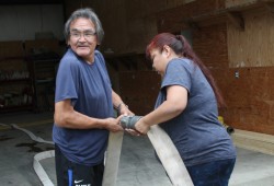 Cecil Joseph and Donna Peter attach hoses at the Nitinaht fire hall on Aug. 30.