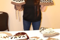 Delia Johnson of Huu-ay-aht displays knitted hats she made.