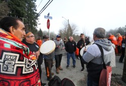 Tseshaht members sing by the ‘Orange Bridge’ on Jan. 21 as traffic was decreased to a single alternating lane to enable the repainting of the landmark. Pictured to the far left is Tom Watts, who is a survivor of the Alberni Indian Residential School.