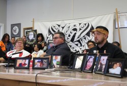 A display showing pictures of loved ones lost to drug overdose sat on a table before Tseshaht Chief Councillor Ken Watts (right), NTC Vice-president Les Doiron and NTC President Judith Sayers on Sept. 19, 2024. Nuu-chah-nulth leaders declared a state of emergency for the ongoing overdose and mental health crisis, calling on more government support to help decline the tragedies. (Eric Plummer photo)