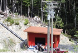 Guests visit the powerhouse on a site tour on Aug. 8 in Hot Springs Cove. As of November 2021, the Hesquiaht First Nation successfully weaned off diesel generators with a 350-kilowatt run-of-river hydropower and solar microgrid that is 100 per cent owned by the First Nation. (Nora O'Malley photo)