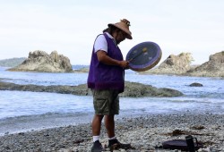 Qiic Qiica sings a traditional song on his drum that features the Three Stars.