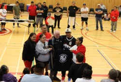 Jason Charleson, centre right, puts his arm around referee Luy Adamo during the Nupps memorial tournament. The Charleson family honoured Adamo for his service.