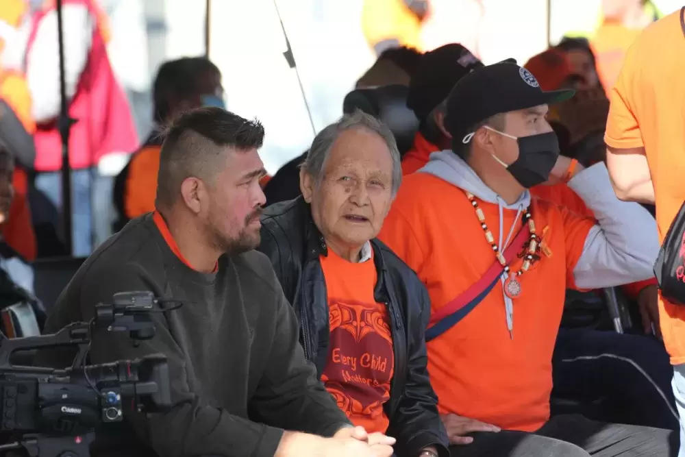 Tseshaht Ha'wilth William Severinson (left), his father Earl Mundy and Ha'wilth Josh Goodwill sit at a gathering on the former site of the Alberni Indian Residential School on Orange Shirt Day, Sept. 30. (Eric Plummer photo)