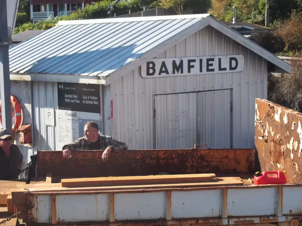 A customer receives shipment of lumber at Bamfield wharf. (Mike Youds photo)