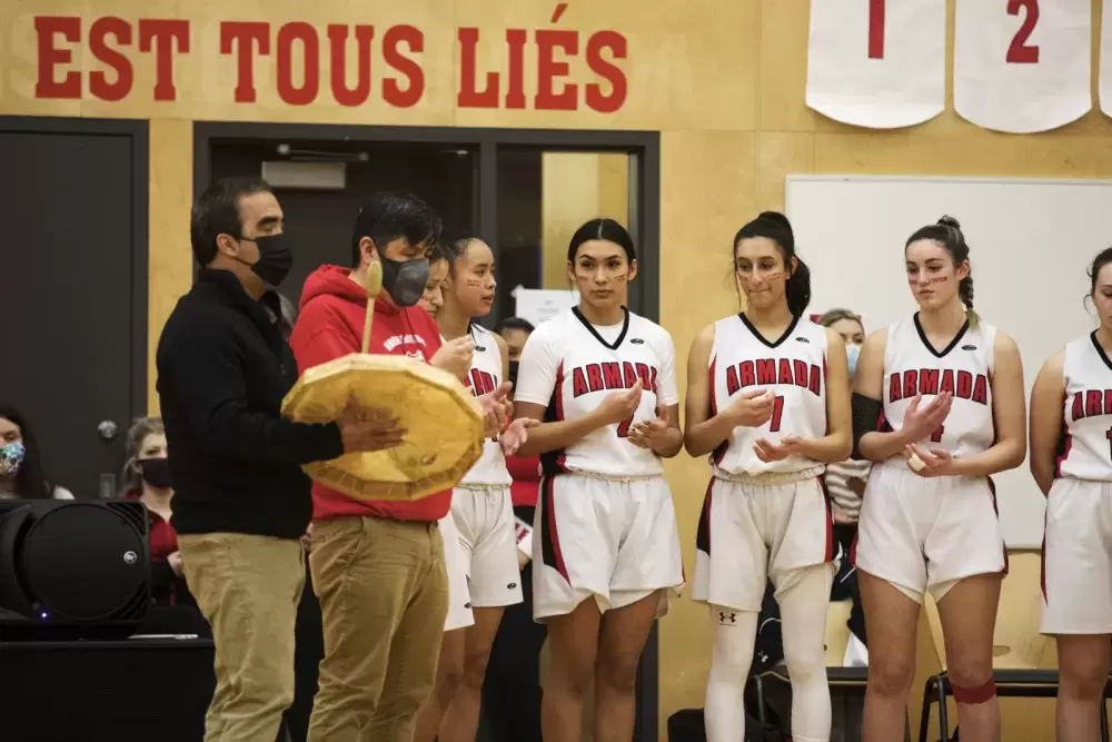 An opening song is sung before the Alberni District Secondary School Armada senior girls' basketball team faces the Kwalikum Kondors senior girls' high school basketball team at the 66th annual Totem Tournament, in Port Alberni, on March 10, 2022.