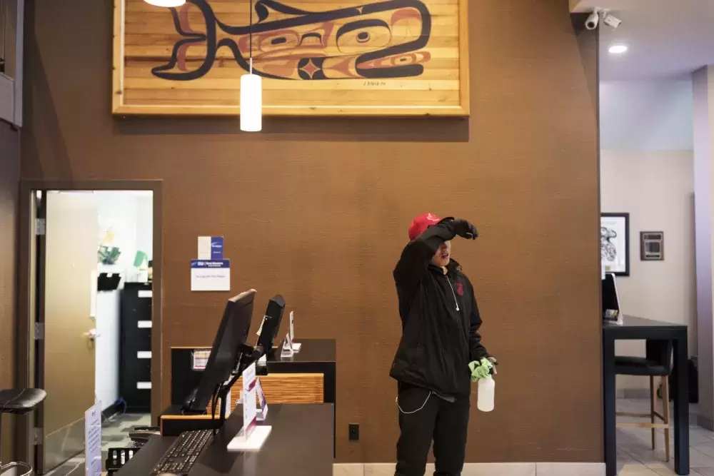 Russell Taylor from Opitsaht cleans the lobby area of the Best Western Tin Wis, on Saturday, March 21, 2020. (Melissa Renwick photo)