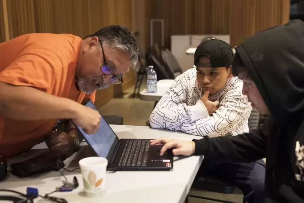 Linus Lucas (left) helps Damion Johnson (right) navigate the genealogy database during the NTC Northern Region Youth Gathering at the House of Unity, in Tsa'xana, near Gold River, on March 29, 2022.