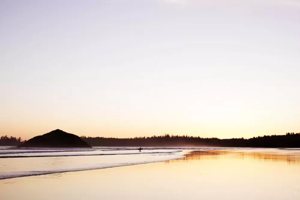 A surfer walks out of the ocean on Long Beach, near Tofino, on April 14, 2021. 