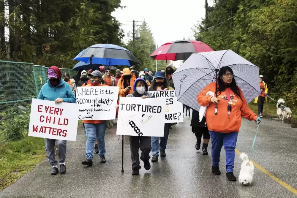 (From left to right) Francis Martin, Nora Martin and Grace Frank lead a march through the streets of Tofino honour the survivors and victims of the residential school system on the first National Day for Truth and Reconciliation, on September 30, 2021.