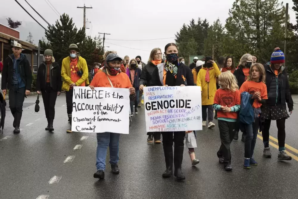 Alice George (left) and Mariah Charleson (right) participate in a march through the streets of Tofino to honour the survivors and victims of the residential school system on the first National Day for Truth and Reconciliation, on September 30, 2021.
