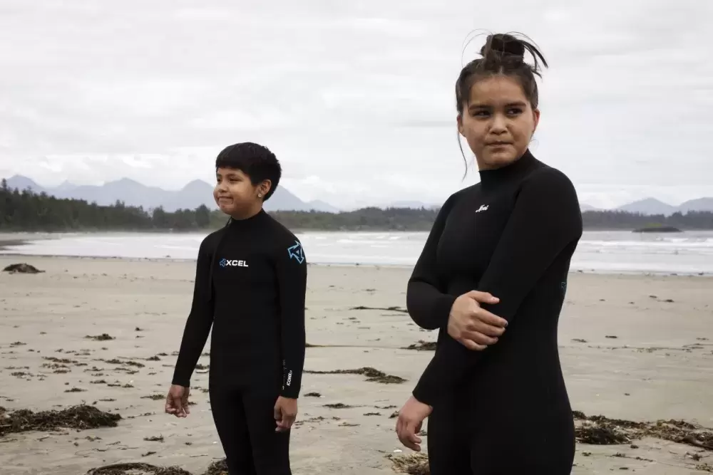 Ali Swan (left) and Cass Frank wait for instruction before heading into the water for surf club, near Tofino, on June 14, 2021.