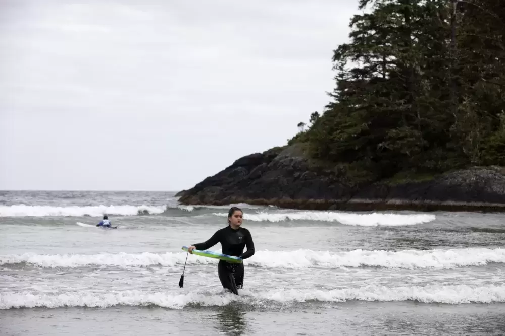 Cass Frank, 13, wades out of the water in front of Esowista during surf club, near Tofino, on June 14, 2021.