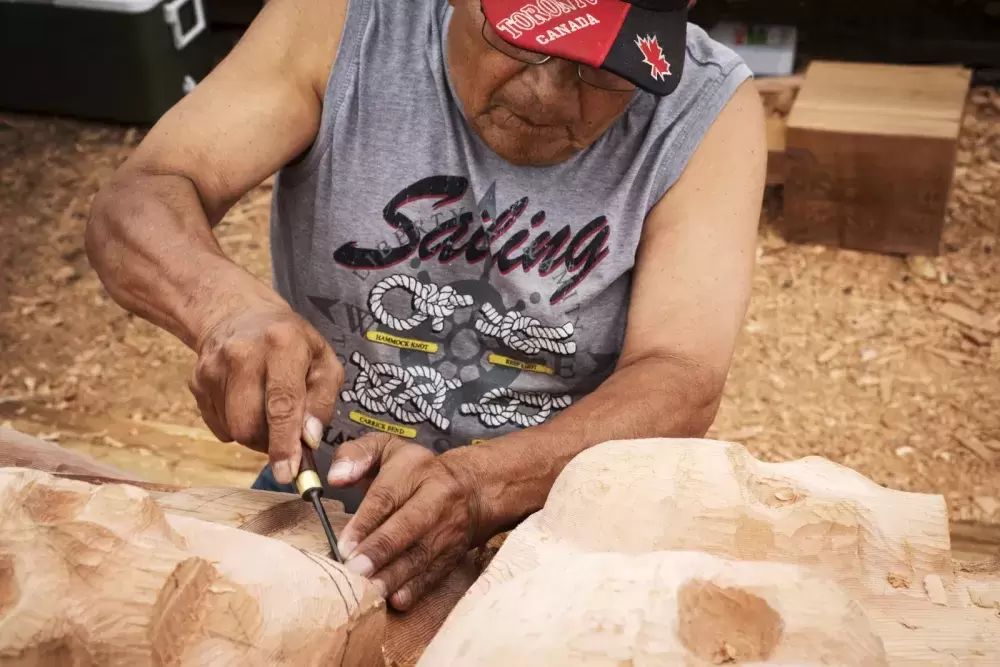 Robert Martin (Nookmis) helps to carve his first totem pole at the Tofino Botanical Gardens, on July 9, 2021.