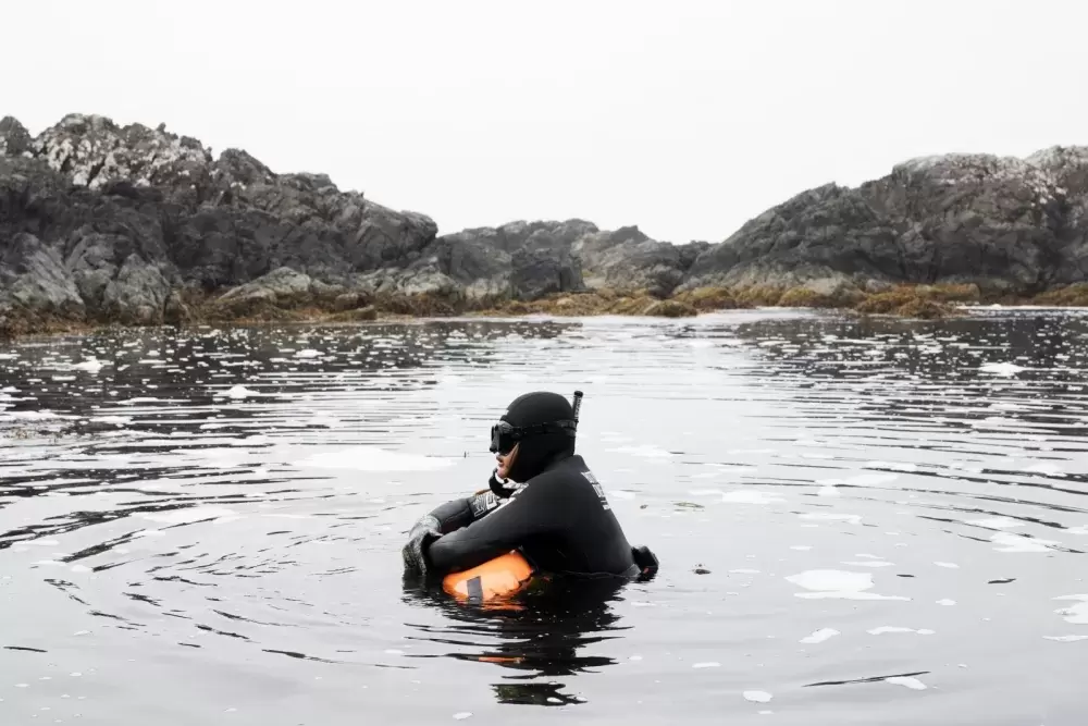 Jaidin Knighton waits as the rest of the group puts on their fins and masks before snorkelling along the Wild Pacific Trail, in Ucluelet, on August 18, 2021.