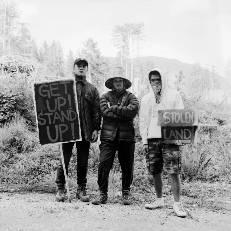 (From left to right) Patrick Jones, Aya Clappis and Victor Peter stand together at the Fairy Creek blockade headquarters, near Port Renfrew, on May, 20, 2021.  As protestors continue to show their support by joining the Rainforest Flying Squad at various camps stationed in the Caycuse and Fairy Creek watersheds, Jones said, “it makes me feel good.”  “It makes me feel like not everybody is just in it for greed,” he said. “They see the beauty in nature and how it should be preserved.”