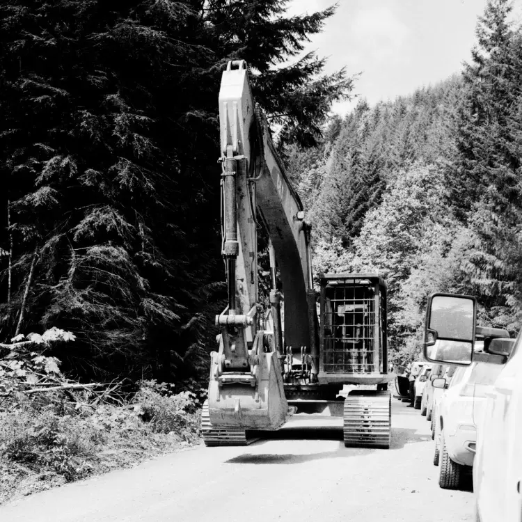 An excavator drives along a logging road in the Caycuse watershed, on May 20, 2021.