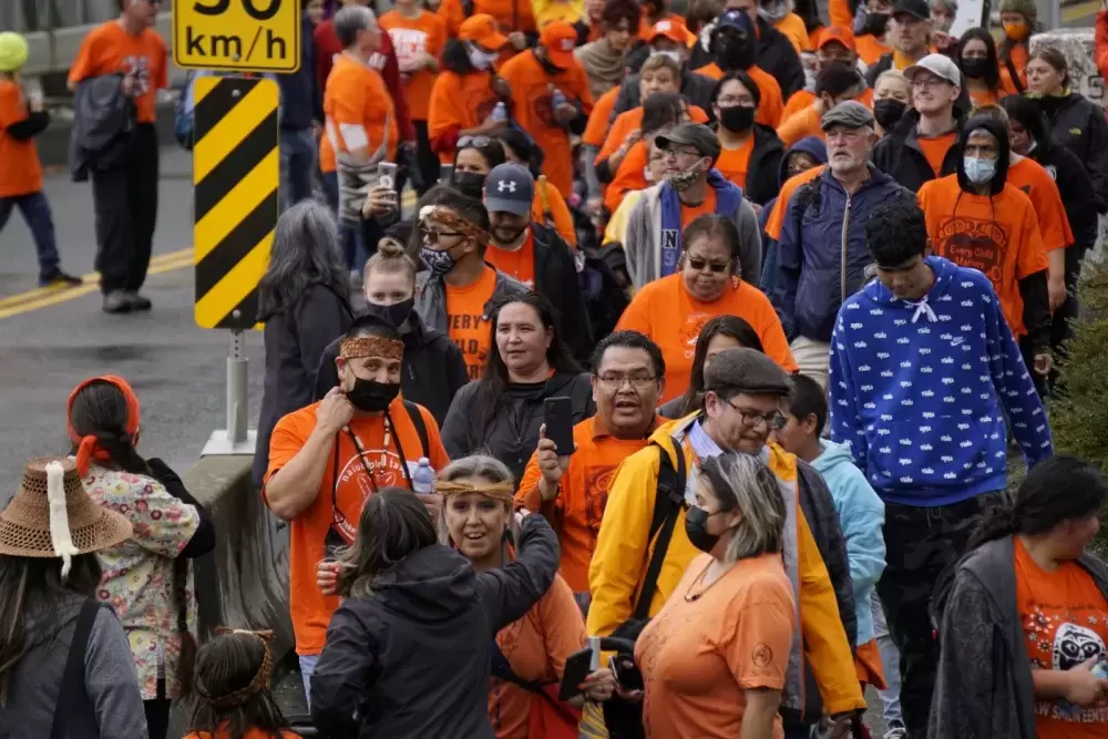 A crowd walks over the Orange Bridge to Maht Mahs gym on Sept. 30 to honour residential school survivors, and those who didn't make it home, for Orange Shirt Day and the first National Day for Truth and Reconciliation. Karly Blats photo