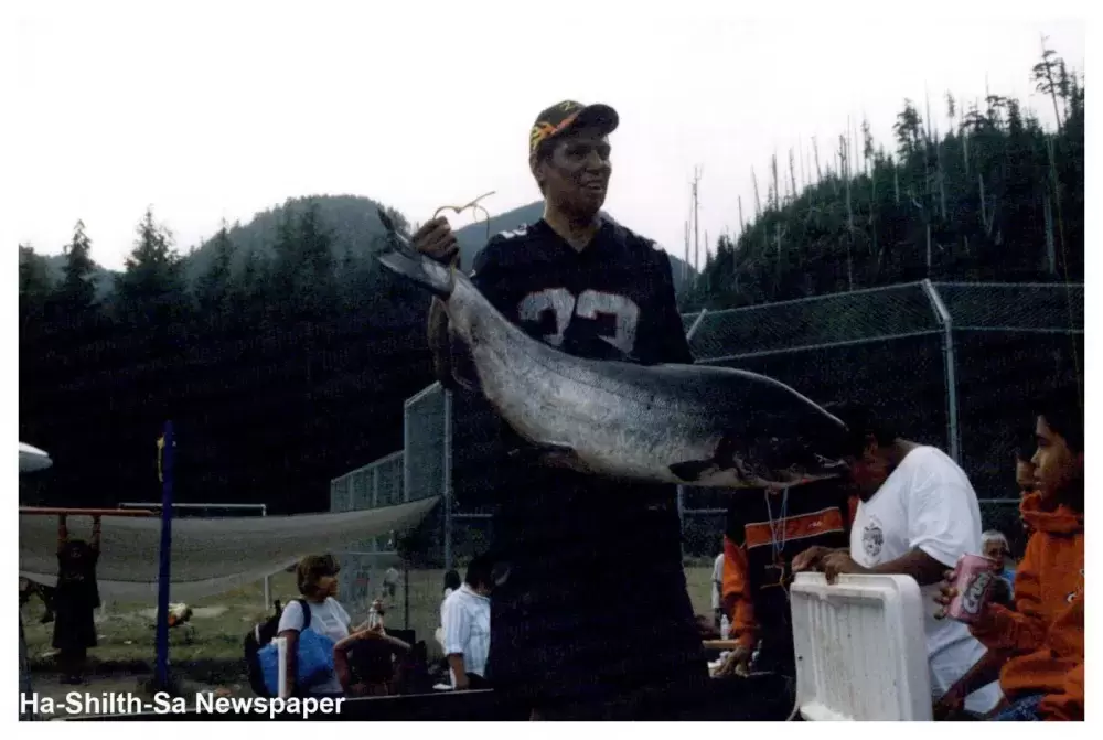 Nuchatlaht member Curtis Michael hoisting a smiley, a Chinook salmon at Oclucje.