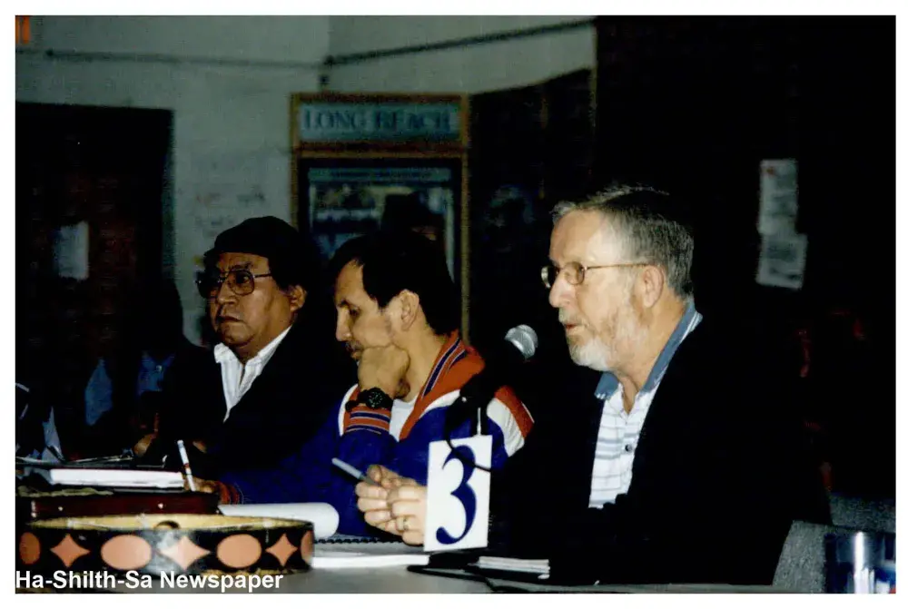 Vic Pearson speaks at a meeting, next to Archie Little (far left) and Richard Watts. 