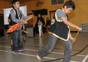 Young students dance for guests